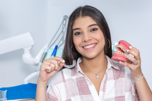 teen holding invisalign and braces