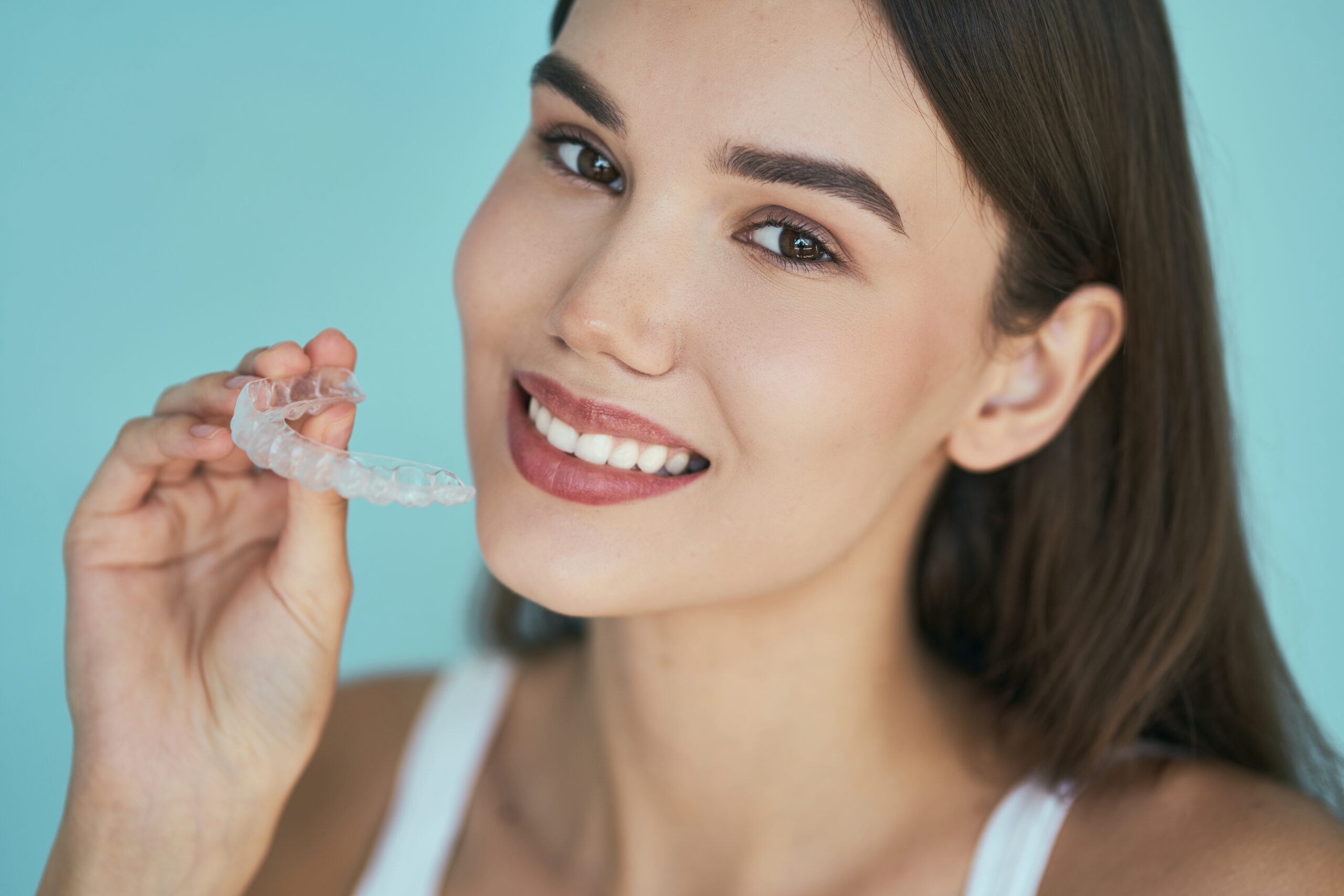 woman with Invisalign aligners and AcceleDent