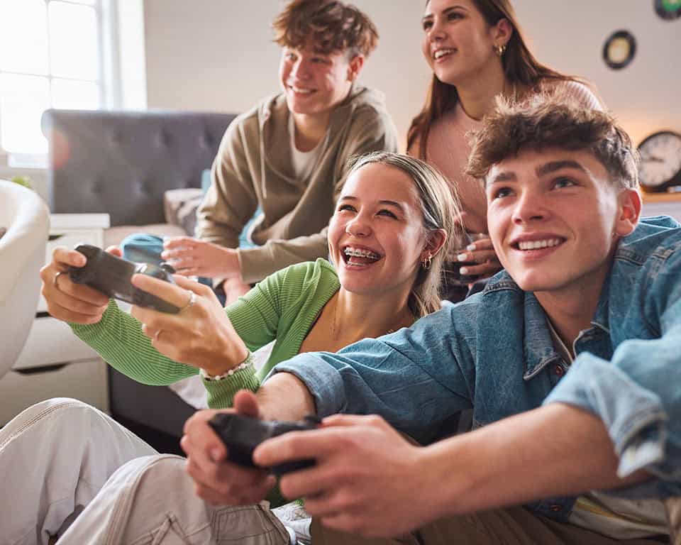 teens playing video games, one with braces on